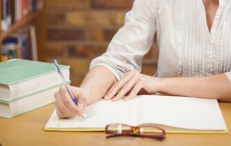woman sitting at desk grading paper